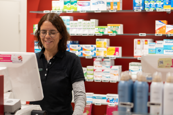 Eine Mitarbeiterin hinter dem Thresen der Apotheke