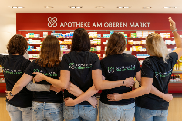 5 Mitarbeiterinnen stehen nebeneinander und umarmen sich