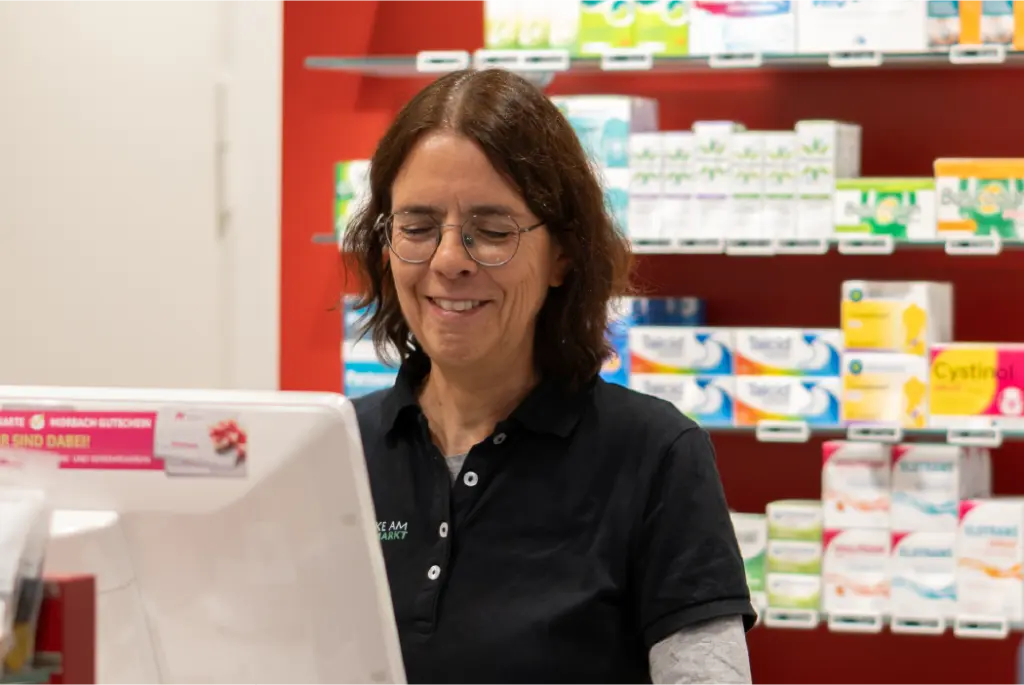 Apothekerin bedient im Offizin einen PC