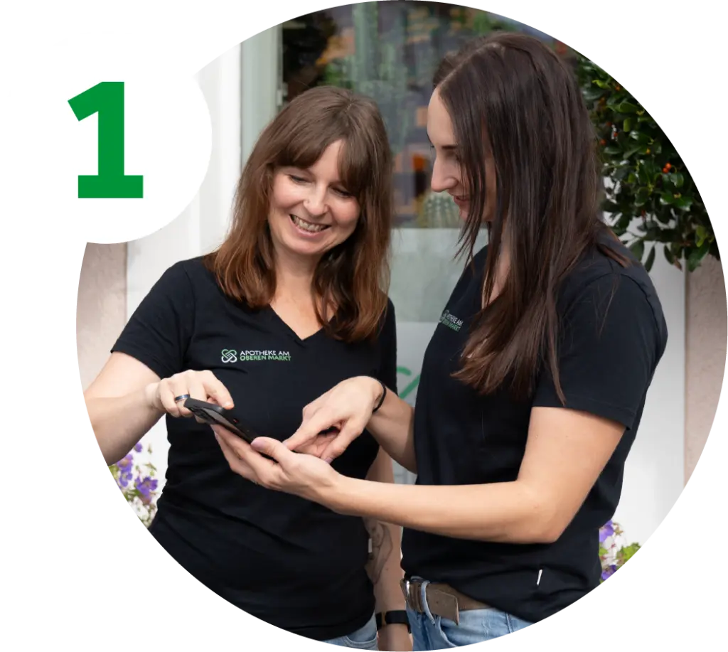 Schritt Eins. Zwei Mitarbeiterinnen bestellen Medikamente per Smartphone